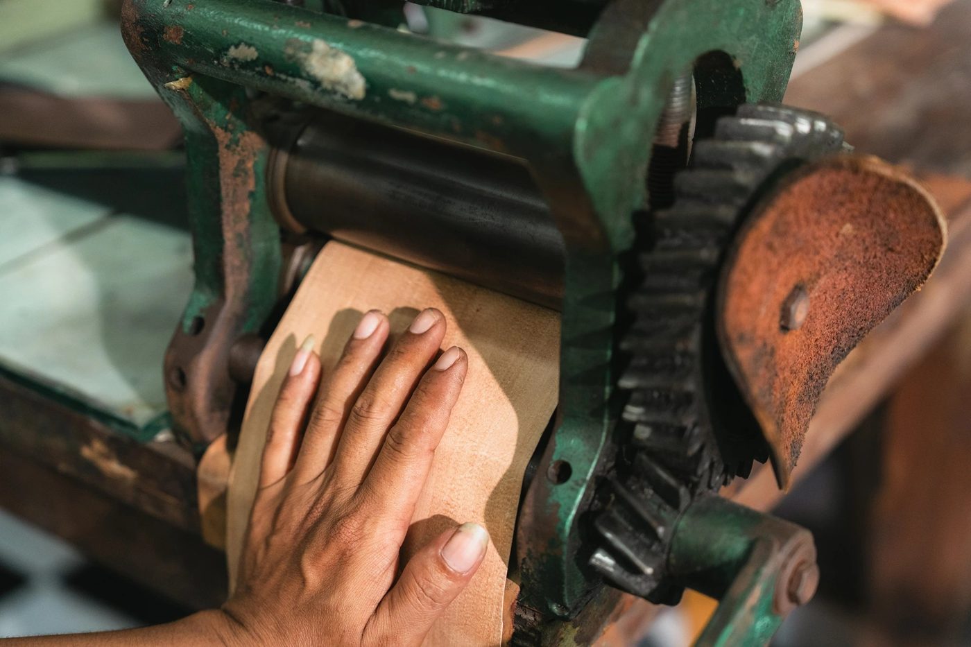 Close-up of leather being thinned on a splitting machine in the Bali workshop